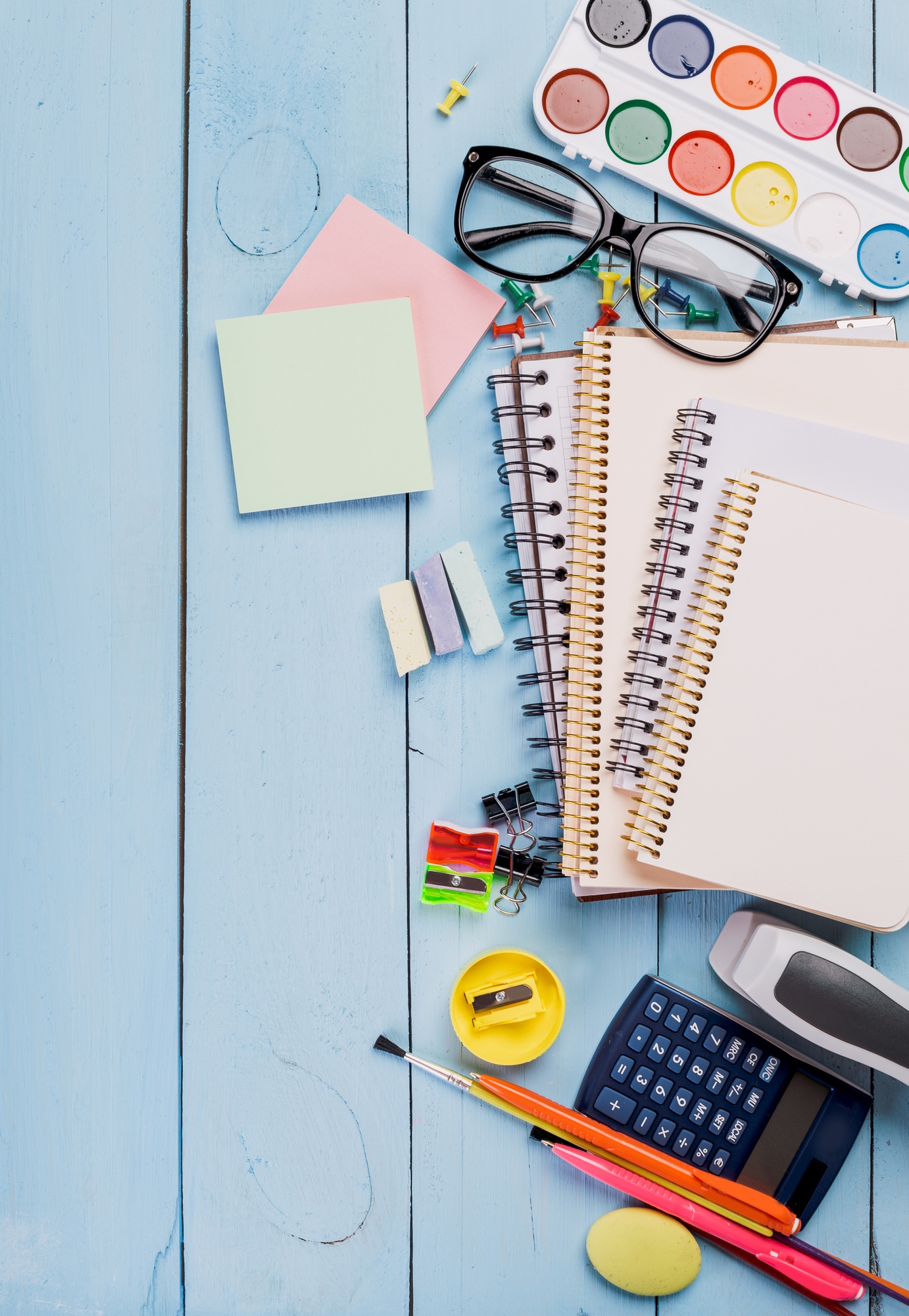 Colorful study materials and supplies arranged on a blue wooden table for creative learning and